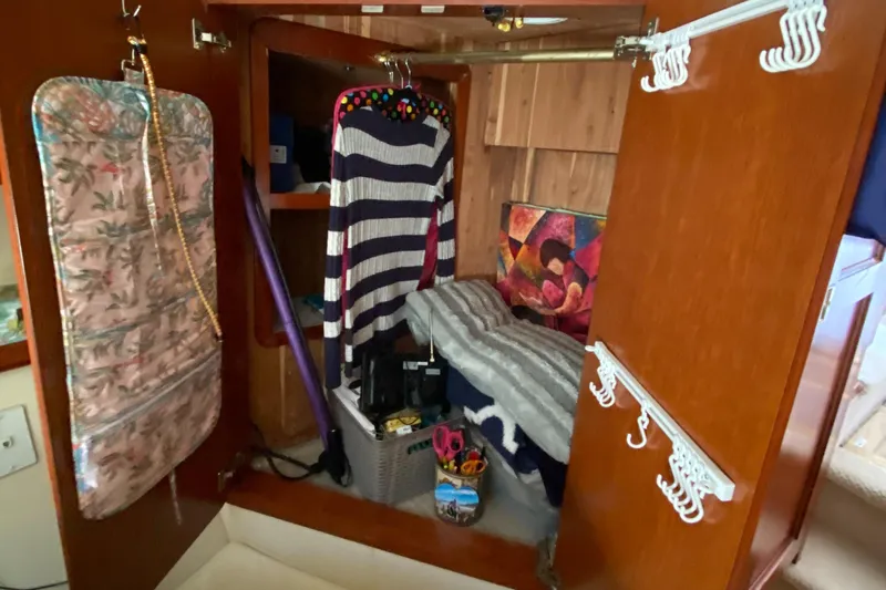 Dianne Yacht Photos Pics Interior closet of 2003 Bluewater Yachts 6000, featuring clothes and storage items.