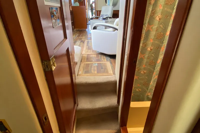 Dianne Yacht Photos Pics Interior view of 2003 Bluewater Yachts 6000, featuring cozy carpeted steps and elegant wood finishes.