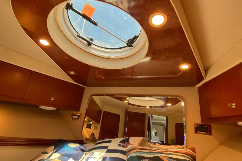 Dianne Yacht Photos Pics Luxurious cabin interior of 2003 Bluewater Yachts 6000, featuring elegant wood finishes and porthole.
