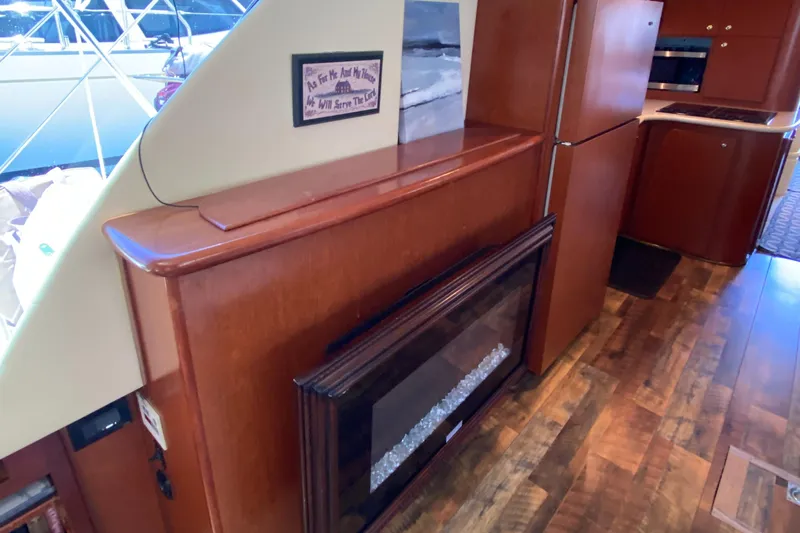 Dianne Yacht Photos Pics Interior of 2003 Bluewater Yachts 6000, featuring wood cabinetry and a built-in fireplace.