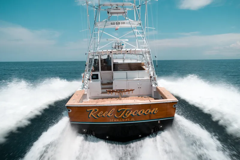 Reel Tycoon Yacht Photos Pics 2004 Donzi R-58 Express boat cruising on open water, rear view.