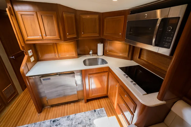 Reel Tycoon Yacht Photos Pics Luxurious kitchen in 2004 Donzi R-58 Express yacht with wood cabinetry and modern appliances.