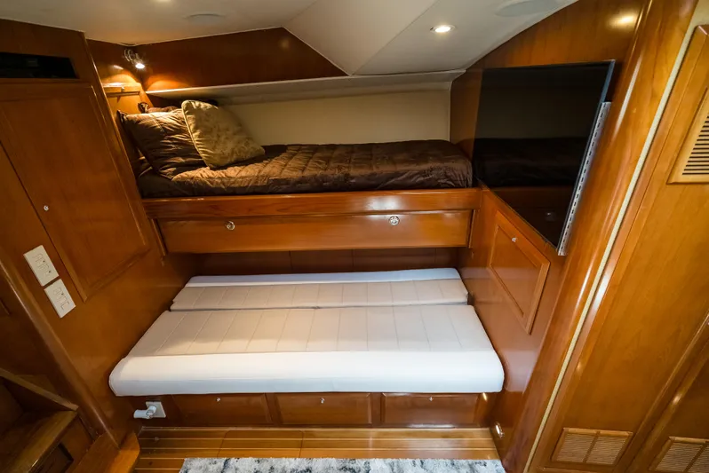 Reel Tycoon Yacht Photos Pics Luxurious 2004 Donzi R-58 Express cabin interior with wooden finish and cozy bedding.