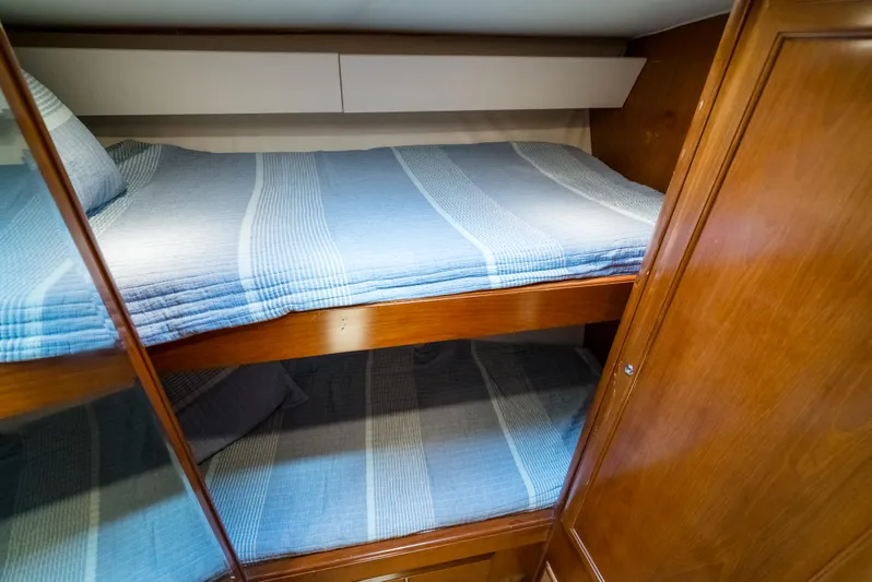 Reel Tycoon Yacht Photos Pics Bunk beds with blue striped bedding in 2004 Donzi R-58 Express yacht cabin.