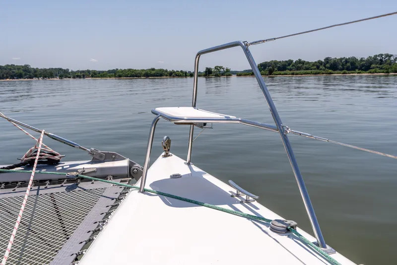 Atlas Yacht Photos Pics Bow of 2006 St Francis SF50 catamaran on calm water with distant shoreline.