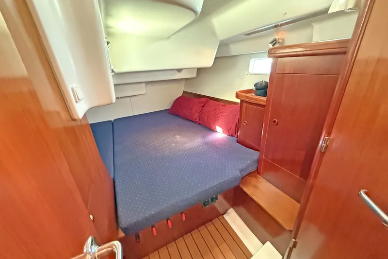 Bellabeaupied Yacht Photos Pics Interior cabin of 2004 Beneteau 473 yacht with cozy bed and wooden furnishings.