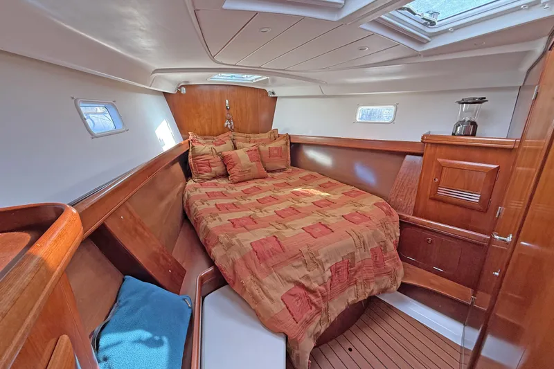 Bellabeaupied Yacht Photos Pics Luxurious cabin interior of a 2004 Beneteau 473 yacht with cozy bedding and wooden finishes.