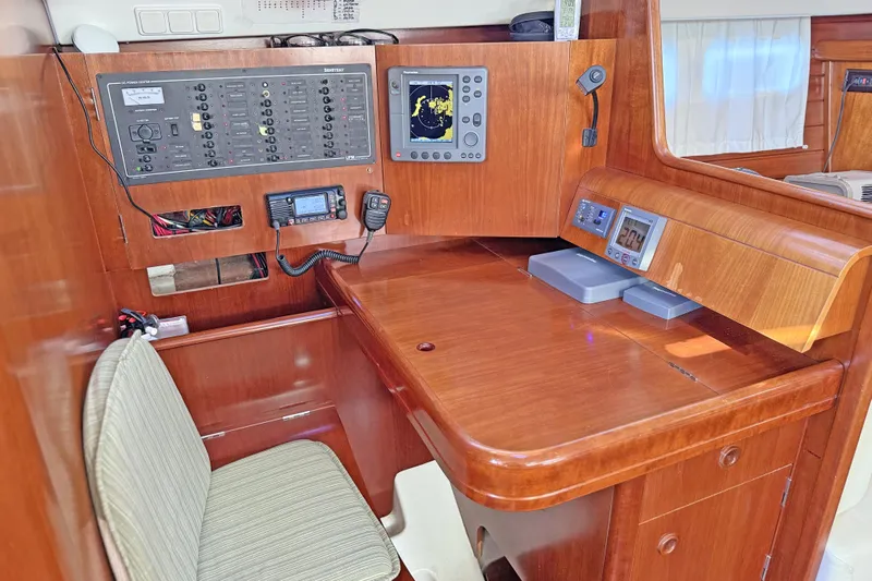 Bellabeaupied Yacht Photos Pics Navigation station of 2004 Beneteau 473 yacht with control panels and seating.