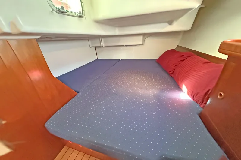 Bellabeaupied Yacht Photos Pics Cozy cabin interior of 2004 Beneteau 473 sailboat with blue bedding and wooden accents.