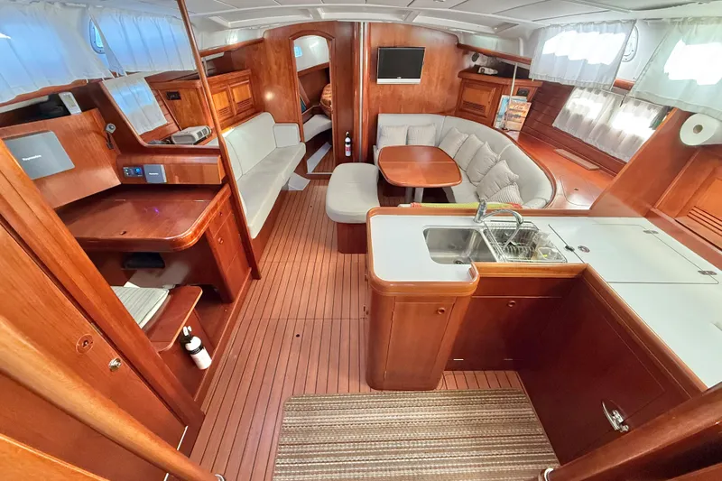 Bellabeaupied Yacht Photos Pics Luxurious interior of 2004 Beneteau 473 yacht with wood finish and cozy seating area.