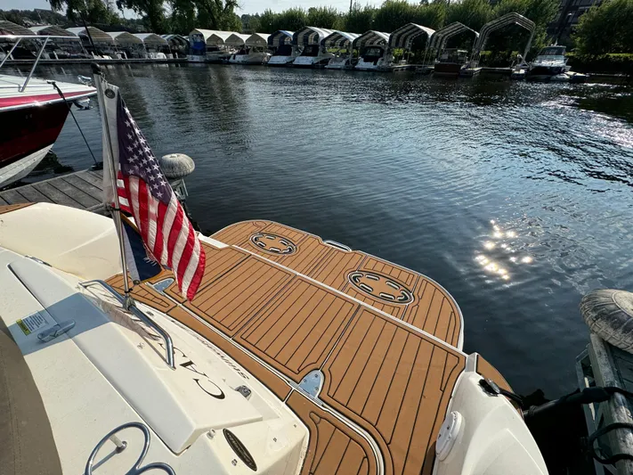  Yacht Photos Pics 2014 Sea Ray 330 Sundancer boat docked, featuring a wooden deck and American flag.