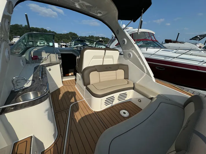  Yacht Photos Pics 2014 Sea Ray 330 Sundancer interior with seating and kitchenette, docked at marina.