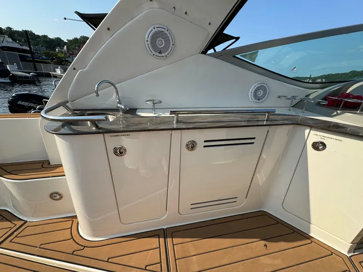  Yacht Photos Pics 2014 Sea Ray 330 Sundancer boat interior with sleek kitchenette and wooden flooring.