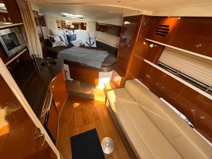 Yacht Photos Pics 2014 Sea Ray 330 Sundancer cabin interior with bed, sofa, and kitchenette.