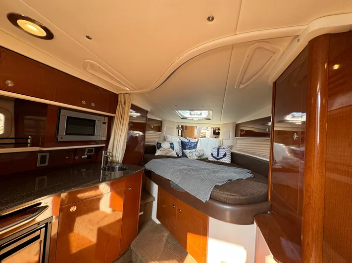  Yacht Photos Pics 2014 Sea Ray 330 Sundancer cabin interior with bed, kitchenette, and wood finish.