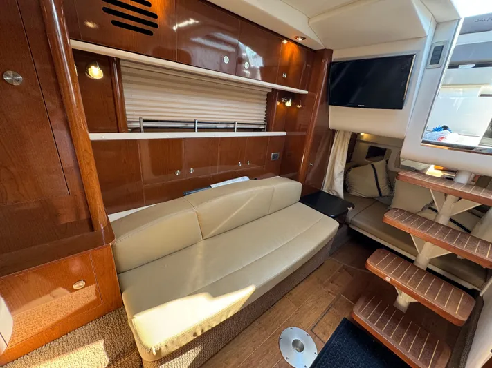  Yacht Photos Pics 2014 Sea Ray 330 Sundancer interior with beige sofa, wooden cabinetry, and stairs.