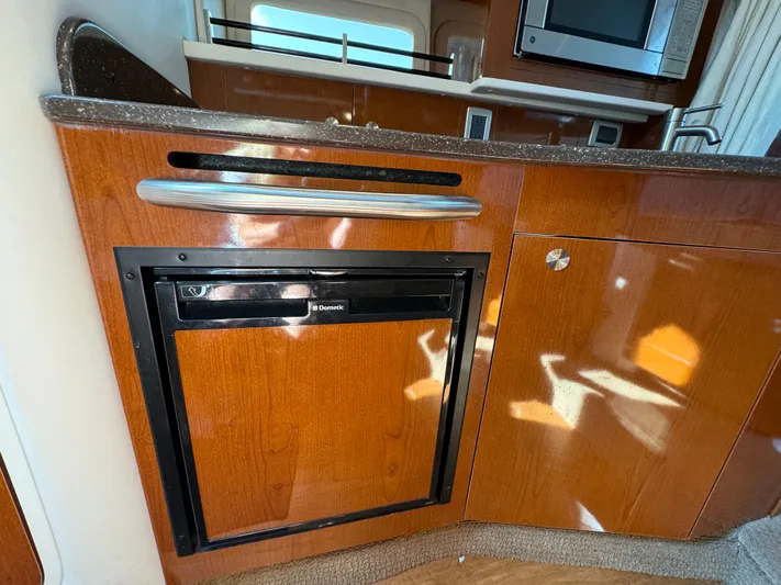  Yacht Photos Pics 2014 Sea Ray 330 Sundancer interior kitchen with wood cabinetry and built-in appliances.
