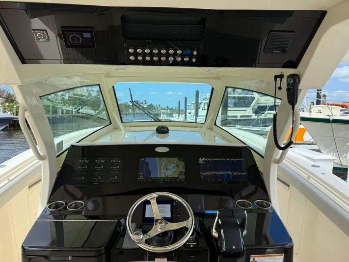  Yacht Photos Pics 2022 Scout 425 LXF boat helm with advanced navigation system and steering wheel.