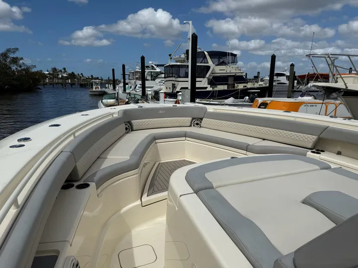  Yacht Photos Pics 2022 Scout 425 LXF boat interior at marina, featuring luxurious seating and clear skies.