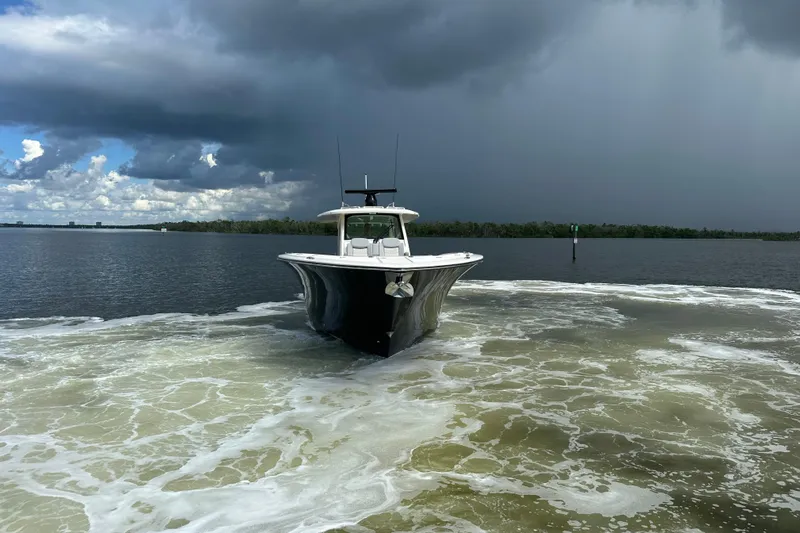  Yacht Photos Pics 2022 Scout 425 LXF boat navigating through calm waters under cloudy skies.