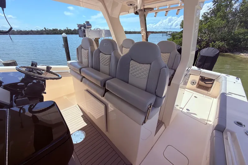  Yacht Photos Pics 2022 Scout 425 LXF boat interior with luxury seating and helm, docked by the water.