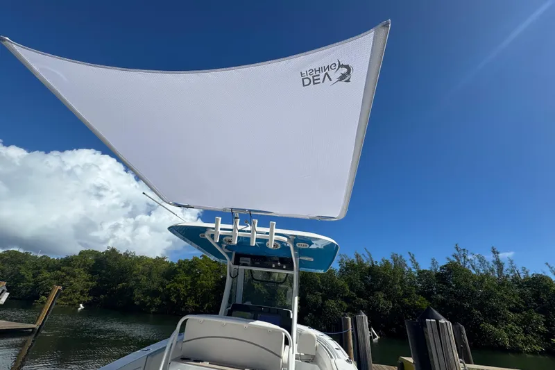  Yacht Photos Pics 2023 Sea Hunt Ultra 305 SE boat with sunshade, docked under clear blue sky.