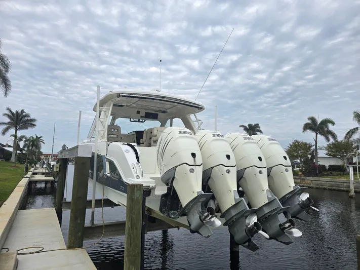  Yacht Photos Pics 2019 Boston Whaler 380 Realm with four outboard engines docked by palm trees.