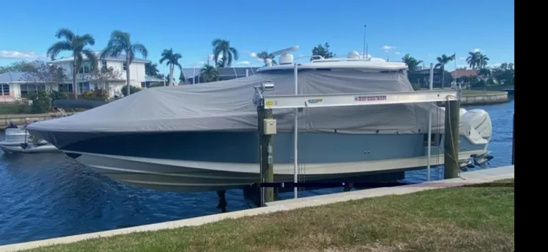  Yacht Photos Pics 2019 Boston Whaler 380 Realm boat covered and docked by a canal.