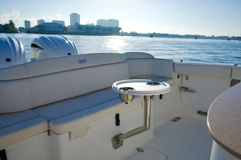 No Name 2024 30 Sea Hunt Yacht Photos Pics 2024 Sea Hunt 305 Ultra boat interior with seating and table, overlooking a scenic waterfront.