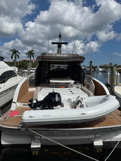  Yacht Photos Pics Azimut Seadeck 6 yacht, 2025 model, docked with inflatable boat, under a partly cloudy sky.