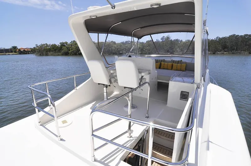  Yacht Photos Pics 2026 Alaska 47 Flybridge yacht with spacious deck and seating, cruising on serene waters.