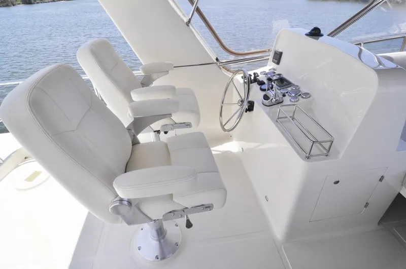  Yacht Photos Pics 2026 Alaska 47 Flybridge helm with dual white captain chairs and steering wheel.