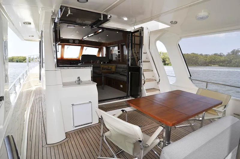  Yacht Photos Pics Luxurious 2026 Alaska 47 Flybridge yacht interior with dining area and scenic water view.