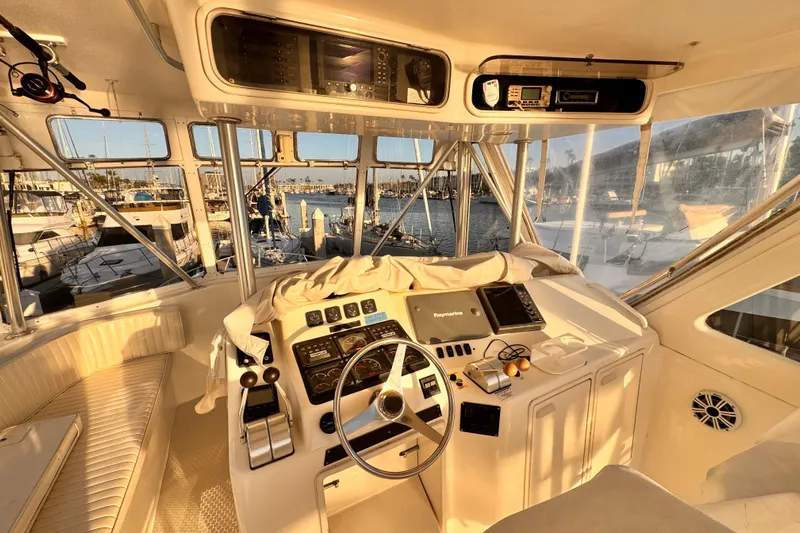 Benyara Yacht Photos Pics 1999 Ocean Yachts 48 Super Sport helm with marina view at sunset.