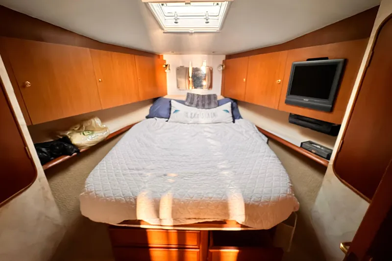 Benyara Yacht Photos Pics Cozy bedroom in 1999 Ocean Yachts 48 Super Sport with wood cabinets and TV.