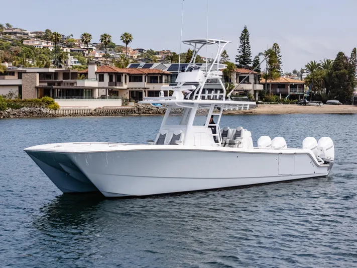  Yacht Photos Pics 2024 Invincible 35 Catamaran on water near luxury waterfront homes.