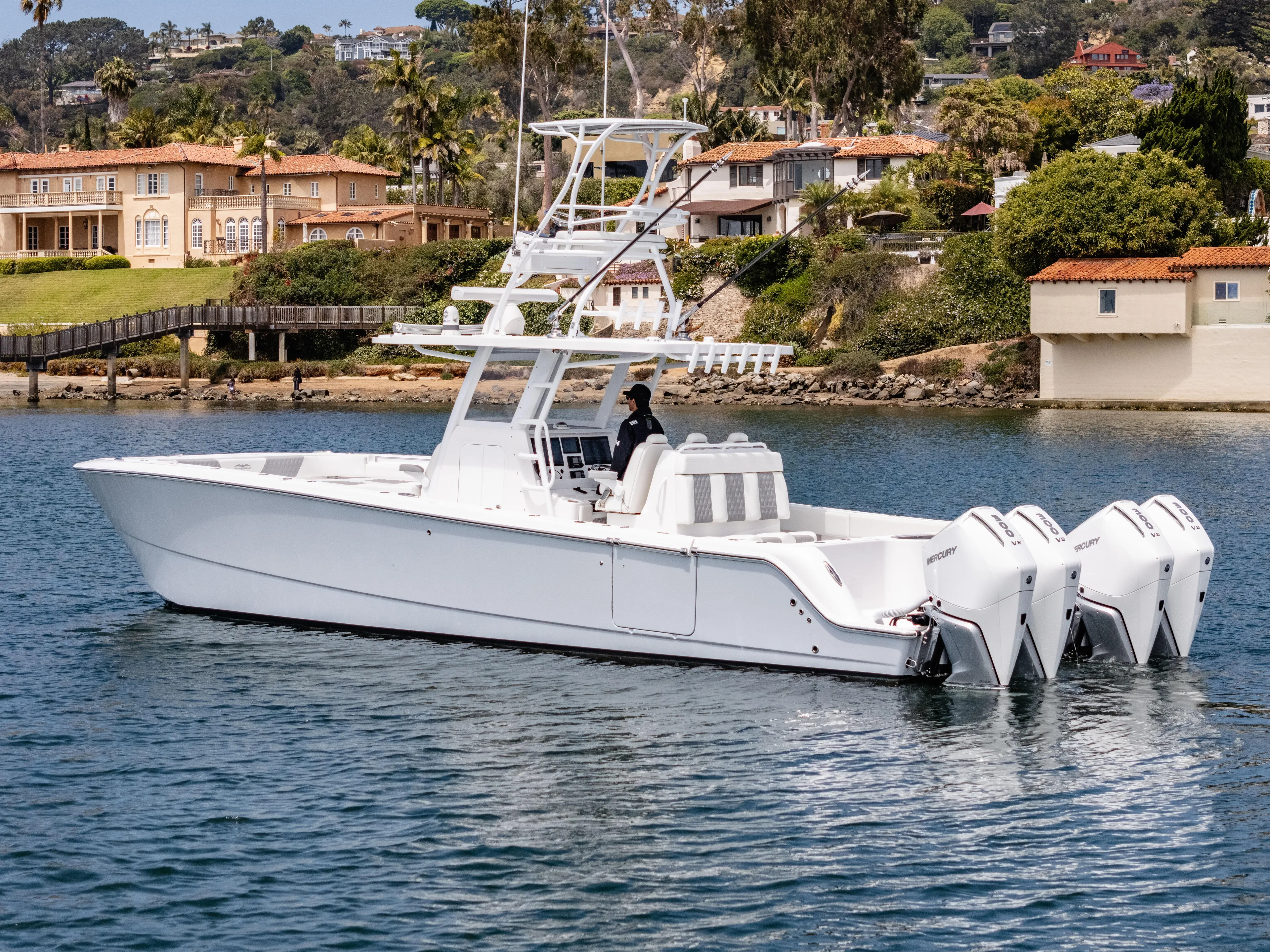  Yacht Photos Pics 2024 Invincible 35 Catamaran cruising near luxurious waterfront homes.