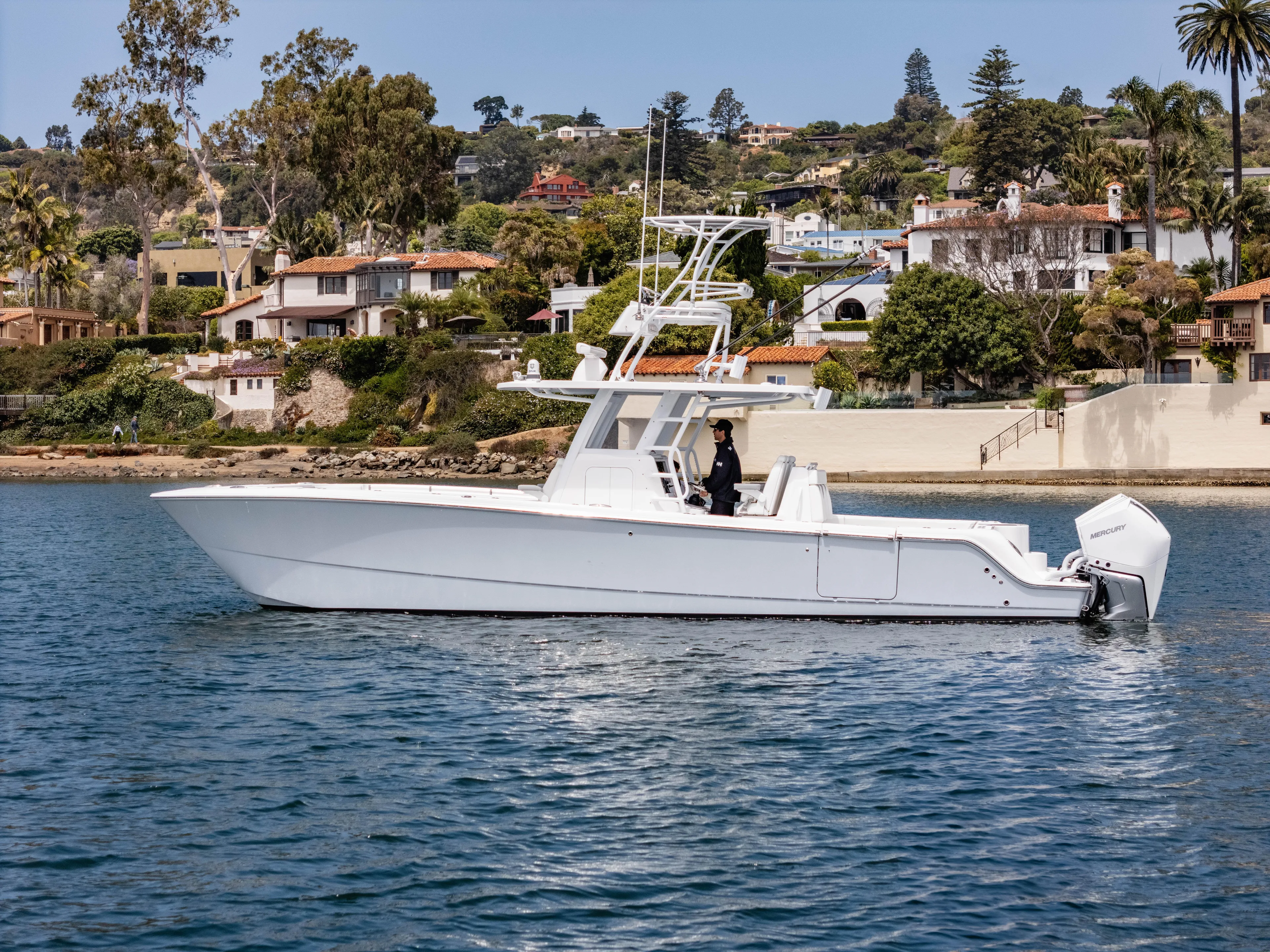  Yacht Photos Pics 2024 Invincible 35 Catamaran cruising near scenic coastal homes.