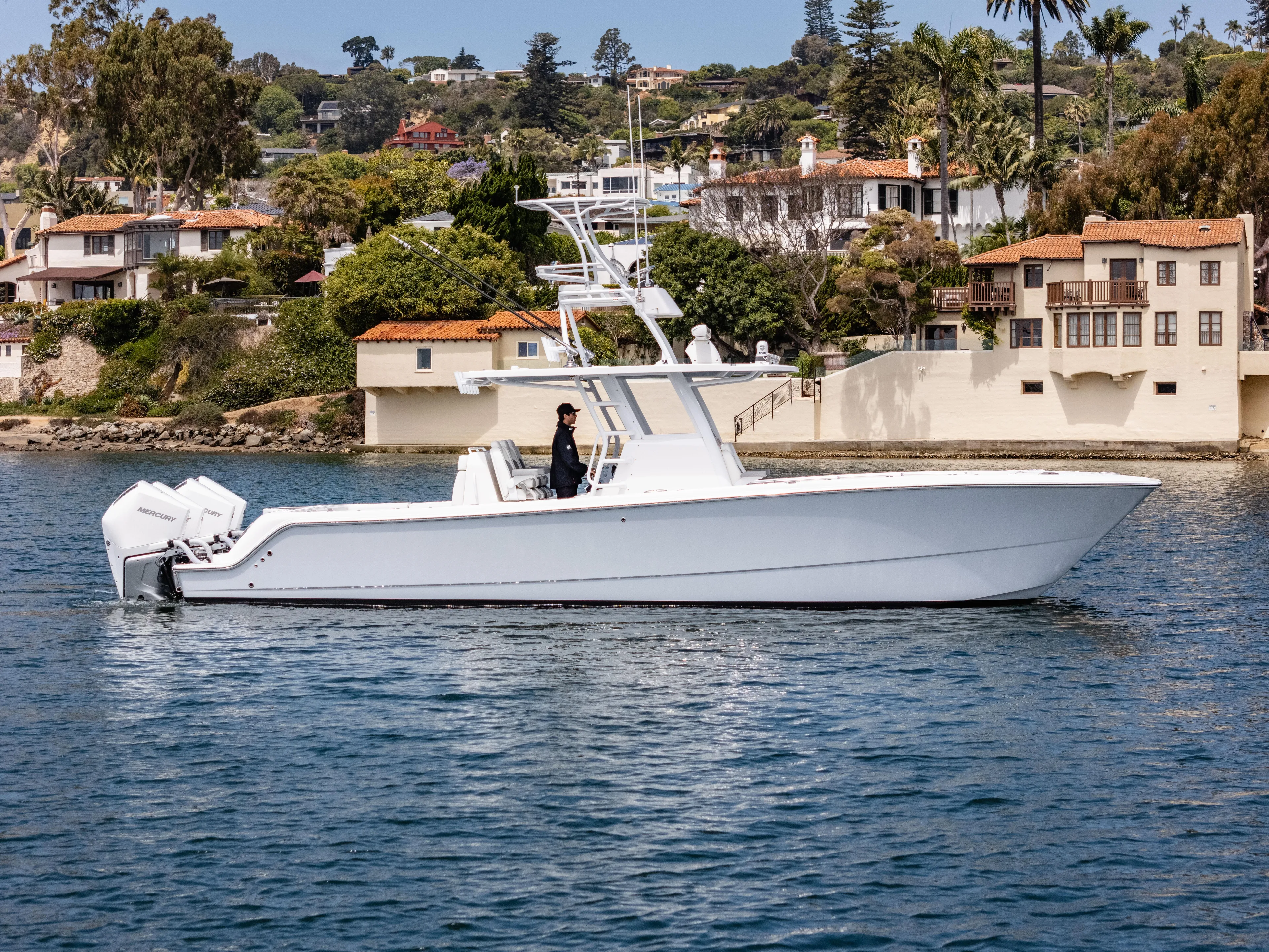  Yacht Photos Pics 2024 Invincible 35 Catamaran cruising near waterfront homes.