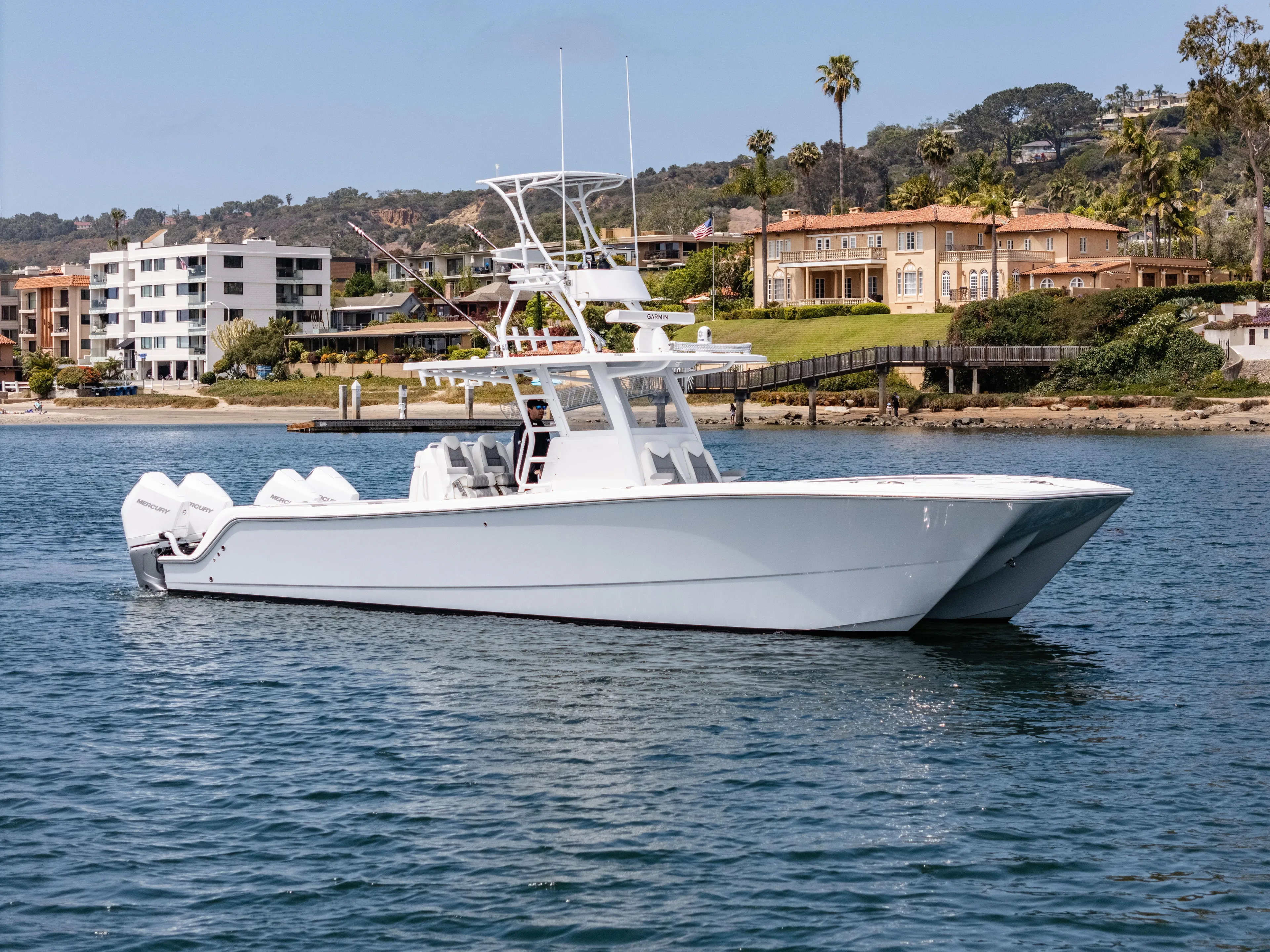  Yacht Photos Pics 2024 Invincible 35 Catamaran cruising near waterfront homes.