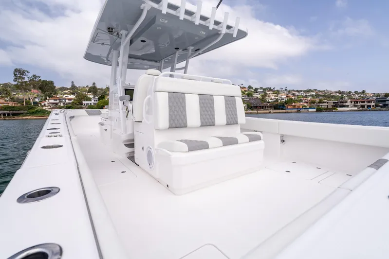  Yacht Photos Pics 2024 Invincible 35 Catamaran with sleek seating, docked near waterfront homes.