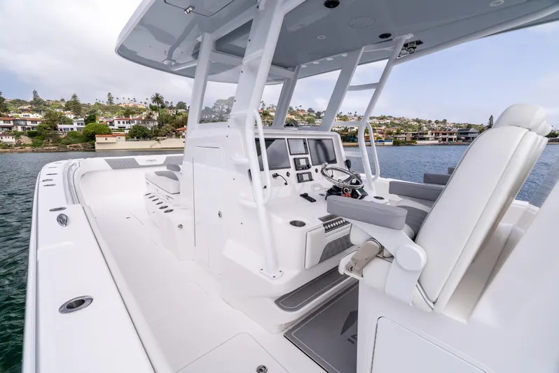  Yacht Photos Pics 2024 Invincible 35 Catamaran interior with modern helm and seating, docked near waterfront homes.