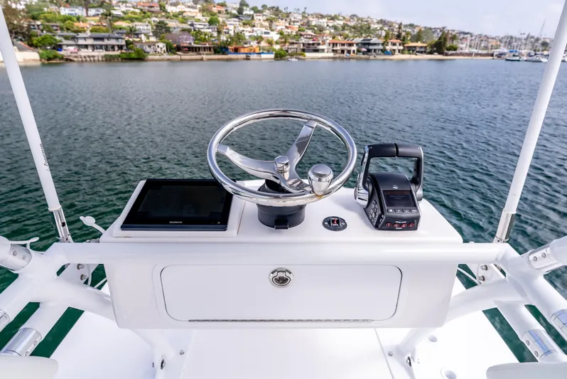  Yacht Photos Pics 2024 Invincible 35 Catamaran helm with steering wheel and controls, overlooking scenic waterfront.