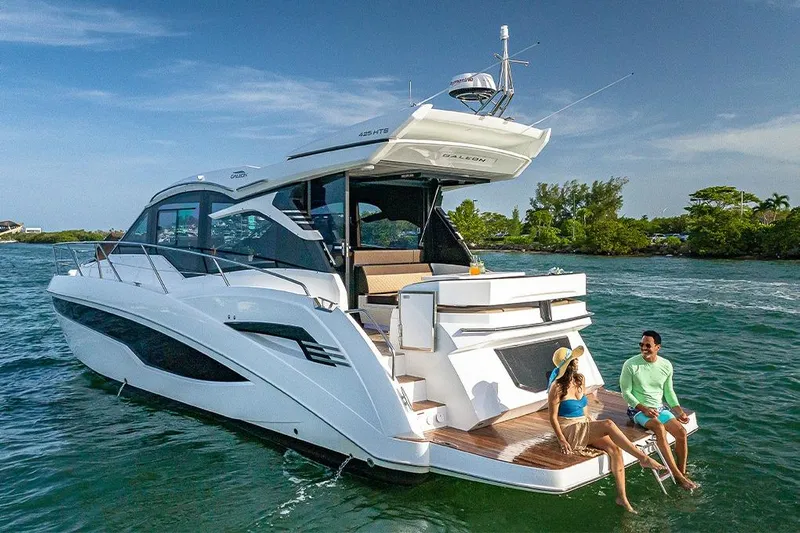  Yacht Photos Pics 2023 Galeon 425 HTS yacht on water, with two people relaxing on the deck.