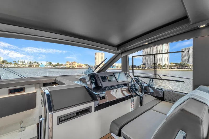  Yacht Photos Pics Interior view of 2023 Galeon 425 HTS yacht helm with waterfront cityscape.