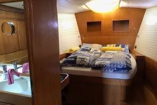 Sinfonie Sylt Yacht Photos Pics Luxurious 2001 Grand Soleil 70 yacht cabin with cozy bedding and elegant wood finish.
