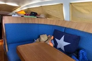 Sinfonie Sylt Yacht Photos Pics Interior of 2001 Grand Soleil 70 yacht with blue seating and wooden table.