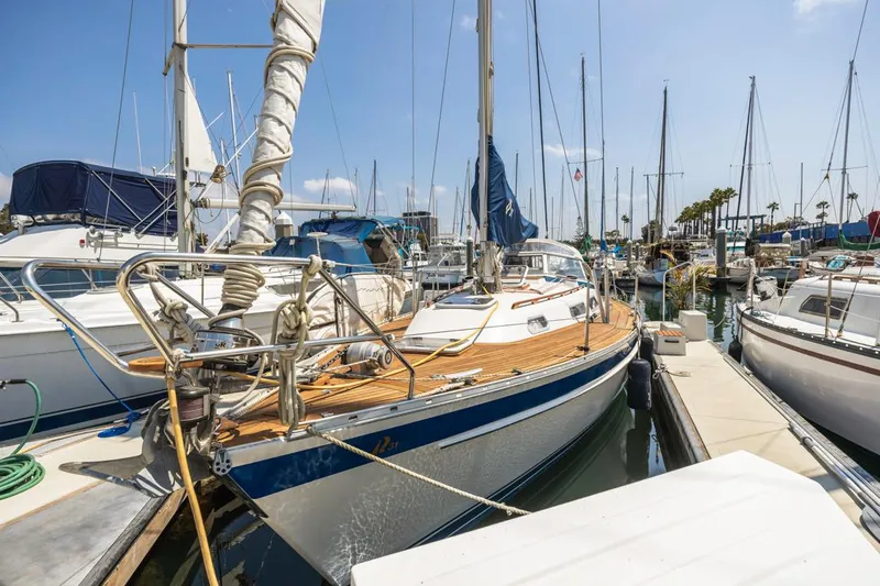 Roniin Yacht Photos Pics 2003 Hallberg-Rassy HR31 sailboat docked in a marina, surrounded by other boats.