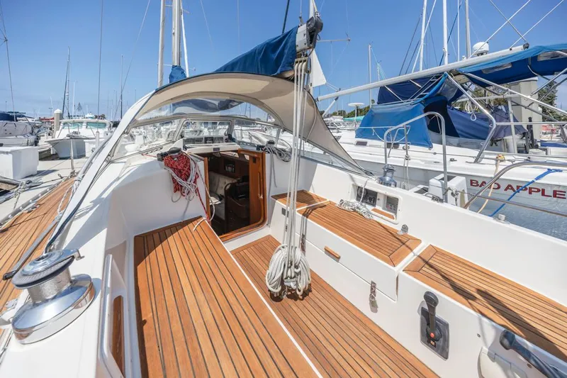 Roniin Yacht Photos Pics 2003 Hallberg-Rassy HR31 sailboat with teak deck, docked in a marina under clear blue skies.