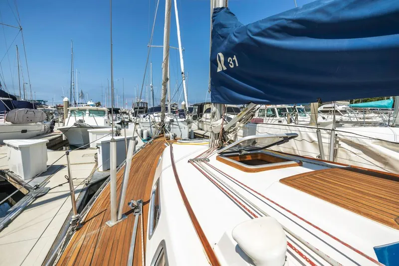 Roniin Yacht Photos Pics 2003 Hallberg-Rassy HR31 sailboat docked at marina, featuring teak deck and blue sail cover.